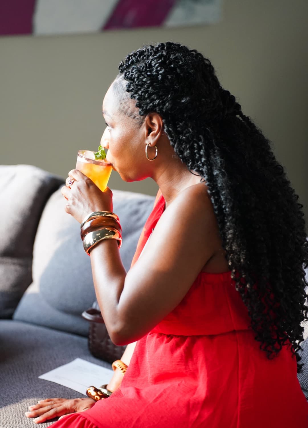 A guest in red sipping a cocktail