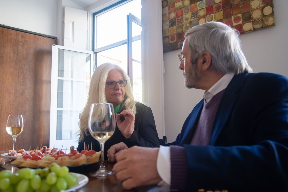 Two people mid-conversation over dinner in a bright room